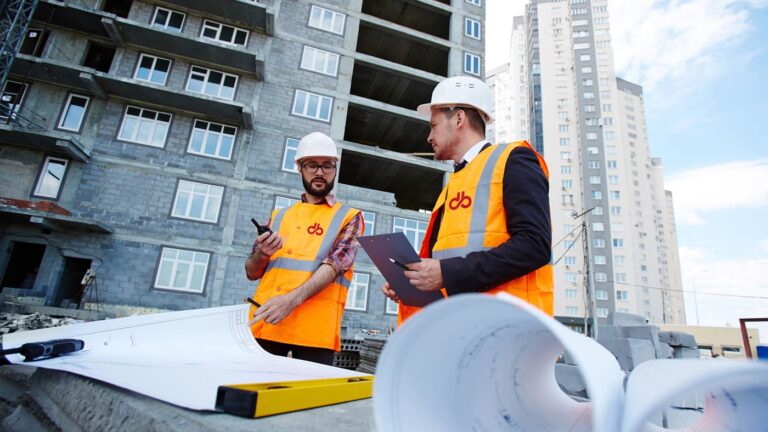 Tecnici di Del Bono S.p.A. in cantiere consultano elaborati tecnici durante la verifica di un intervento edilizio.