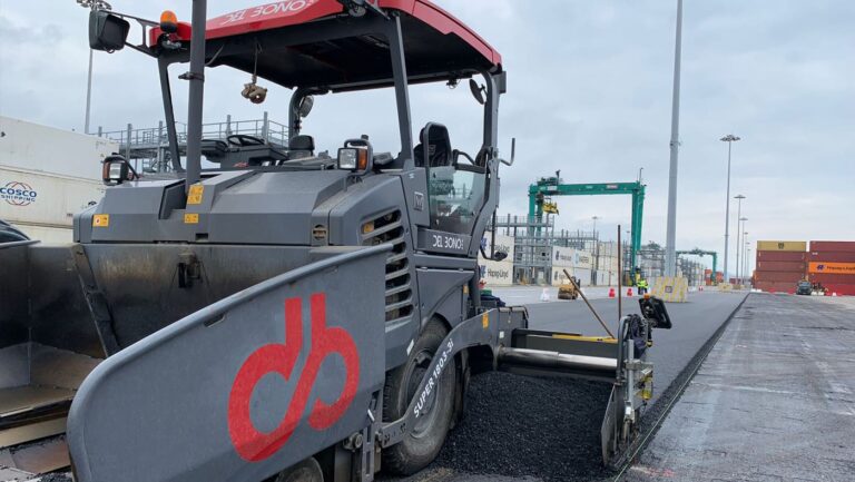 Macchina asfaltatrice Del Bono S.p.A. al lavoro nella realizzazione della pavimentazione stradale in un'area portuale.
